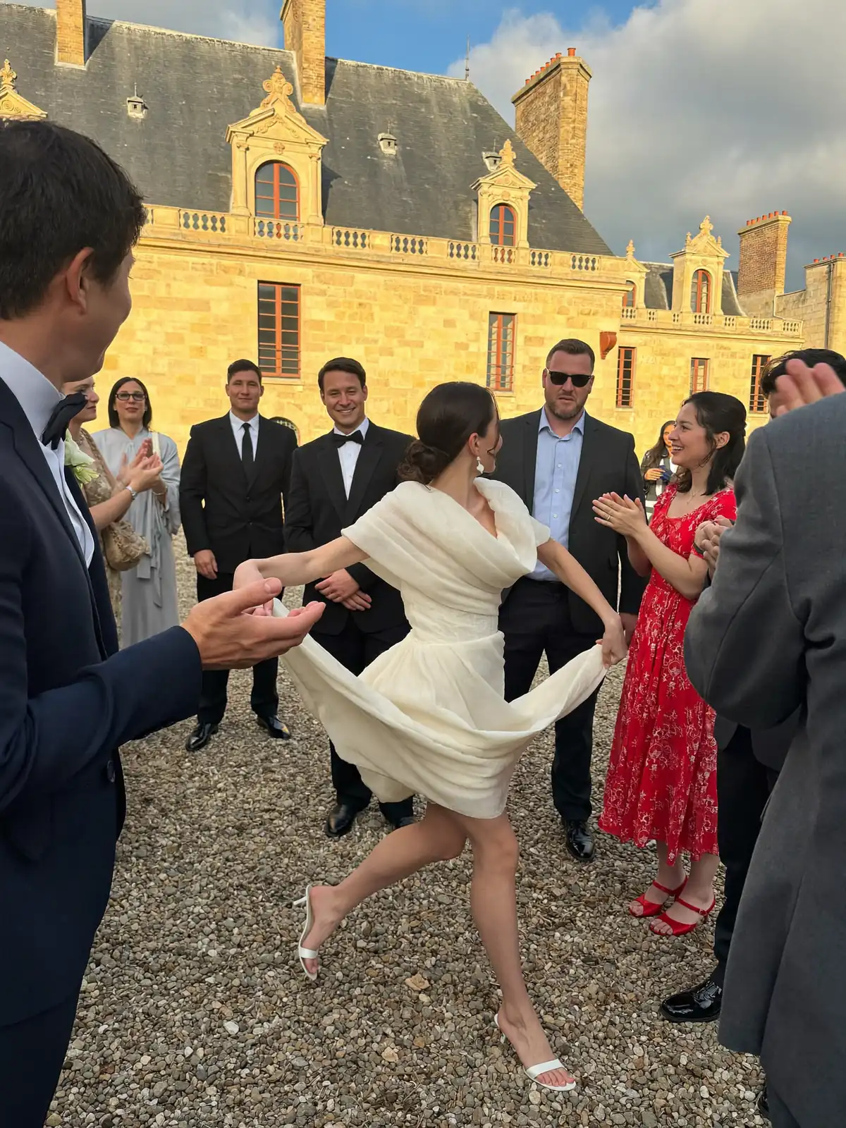 La mariée tourbillonne dans la cour de gravier au soir doré