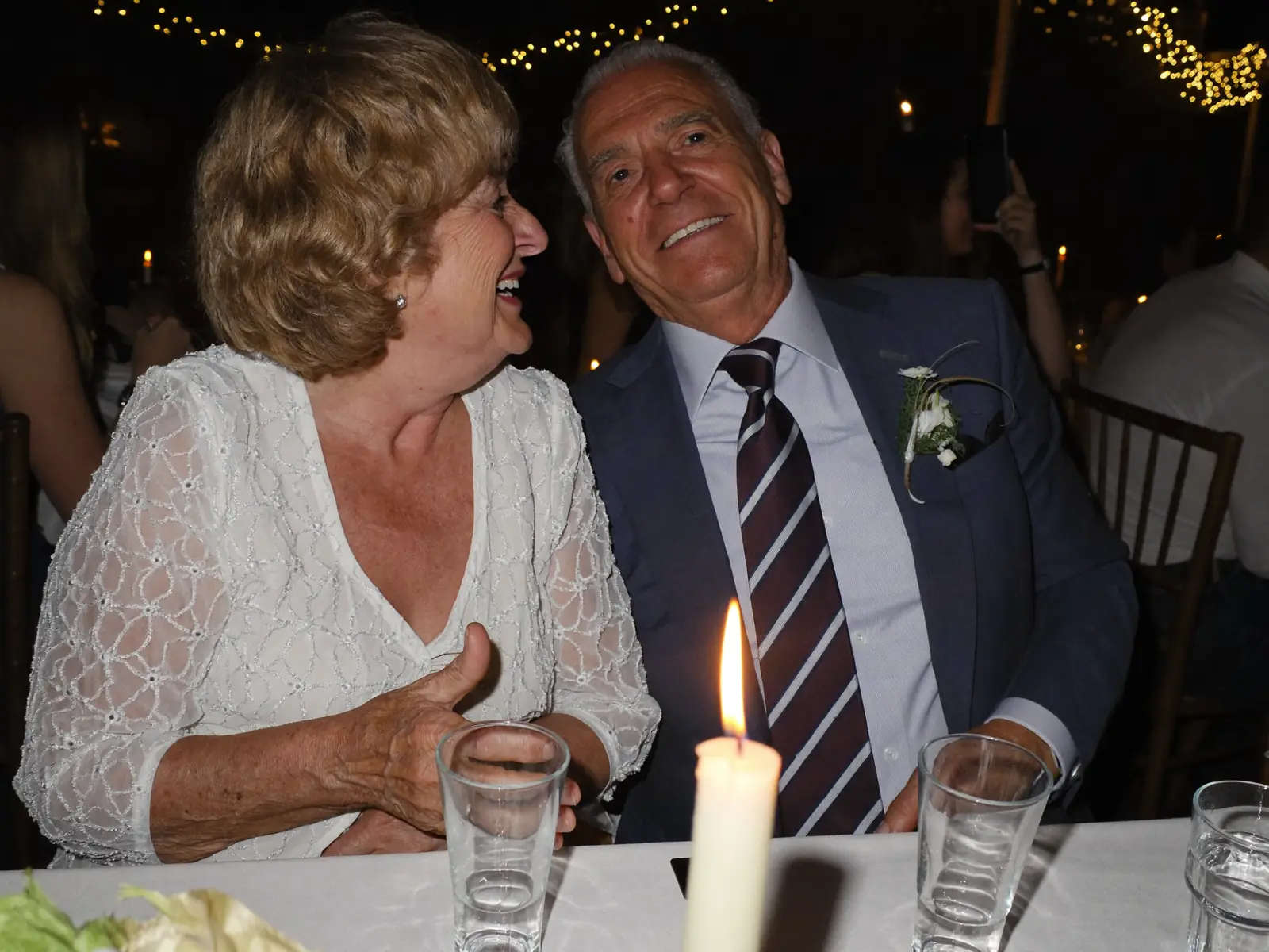 Grand-mère et grand-père riant à la table aux bougies, minuit passé